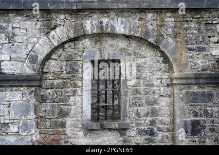 prison bars on window in old stone wall Stock Photo