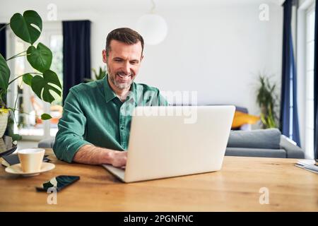 Mature businessman working from home using laptop Stock Photo