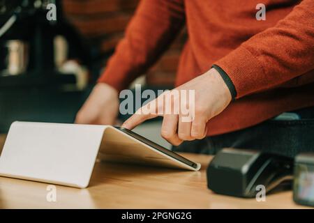 Cafe owner using tablet PC at cafe Stock Photo
