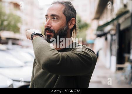 Mature man with beard talking into smart watch Stock Photo