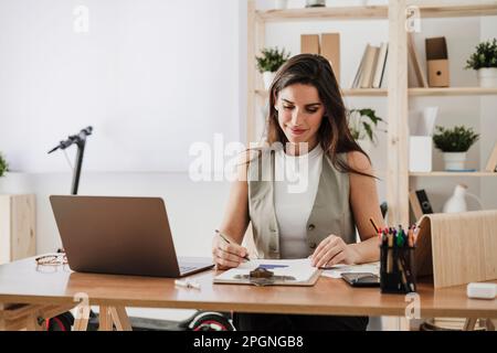 Smiling businesswoman checking with documents in office Stock Photo