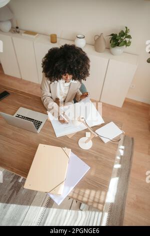 Businesswoman taking notes working in office Stock Photo