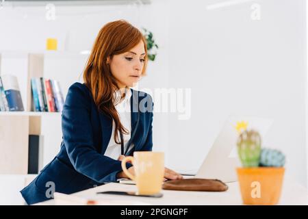 Female freelancer working on laptop at home Stock Photo