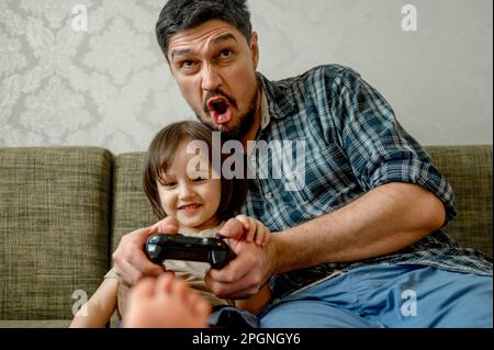 Father playing video game with son at home Stock Photo