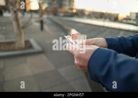 Businessman counting money at office park Stock Photo