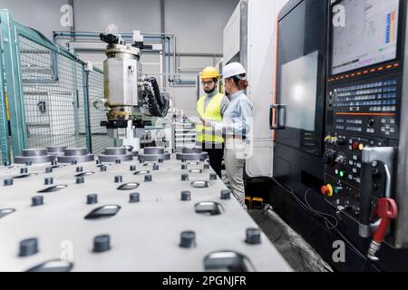 Young engineers working in factory Stock Photo