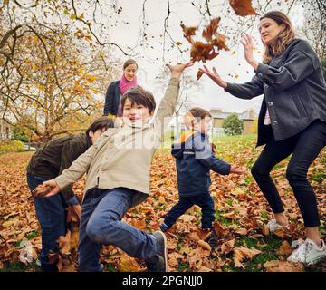 Carefree boy having fun with family at autumn park Stock Photo