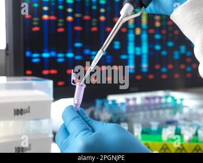 Scientist pouring DNA sample through pipette in test tube Stock Photo