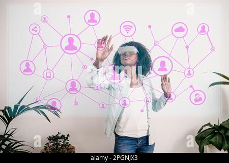 Businesswoman touching virtual network icons at home office Stock Photo