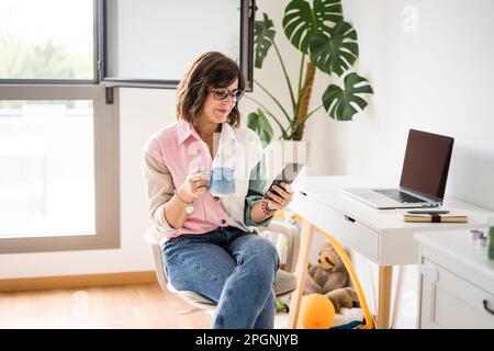 Smiling freelancer using smart phone at home Stock Photo
