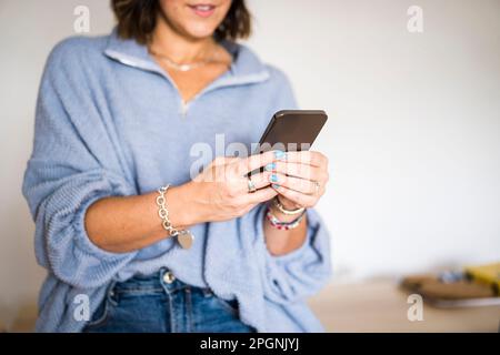 Woman using smart phone at home Stock Photo