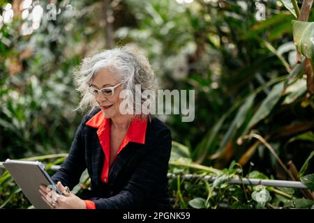 Businesswoman using tablet PC in garden Stock Photo