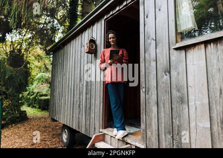 Woman using tablet PC standing in doorway Stock Photo