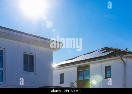 Germany, North Rhine Westphalia, Cologne, Sun shining over modern houses with solar roof panels Stock Photo