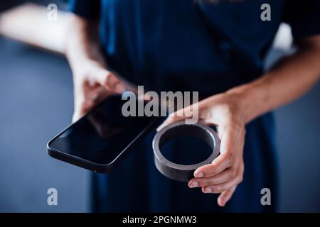 Hands of businesswoman holding circular equipment and smart phone in office Stock Photo