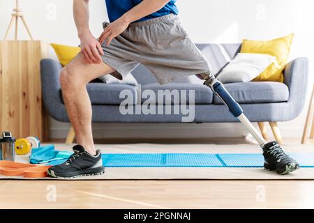 Man with amputated leg stretching in living room Stock Photo