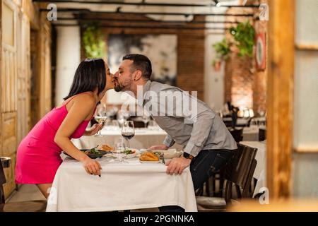 Romantic couple kissing at restaurant Stock Photo
