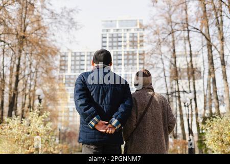 Senior man and woman strolling in autumn park Stock Photo