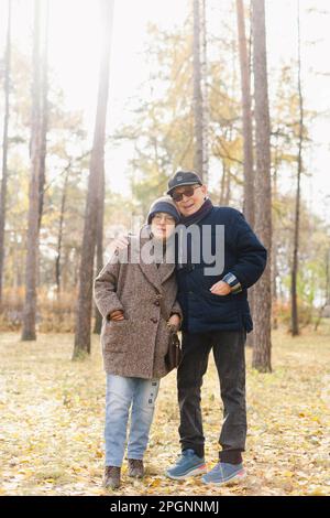 Senior man with arm around woman standing at park Stock Photo