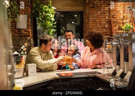 Happy multiracial friends at bar counter having fun in restaurant Stock Photo