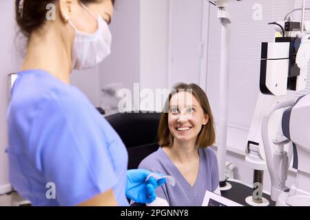 Happy patient looking at doctor in clinic Stock Photo