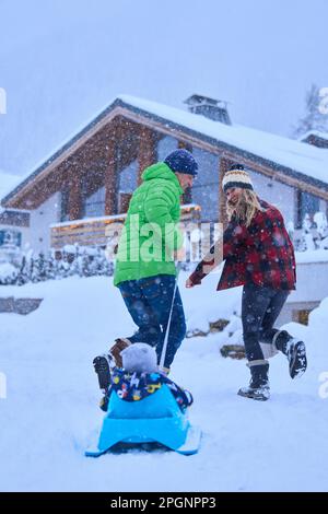 Happy mother and father with son enjoying in snow Stock Photo