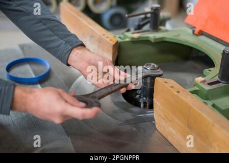 Craftsman fastening nut with wrench in workshop Stock Photo