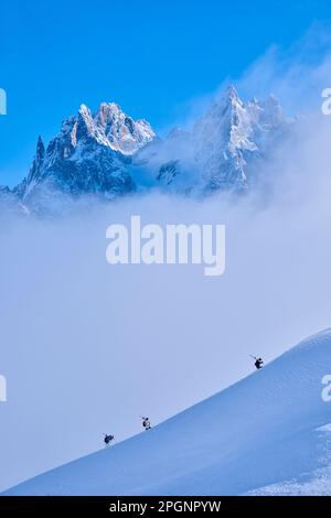 Skiers hiking on snow covered mountain Stock Photo