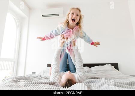 Happy daughter having fun and playing with father at home Stock Photo