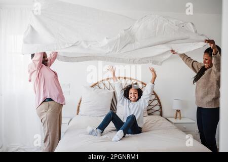 Happy family enjoying together in bedroom at home Stock Photo
