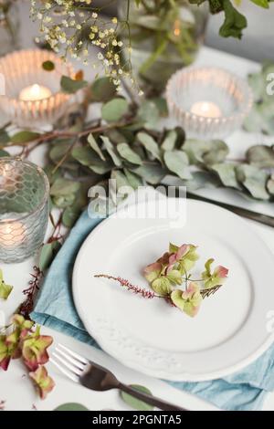 Leaves on plate lying on set table Stock Photo