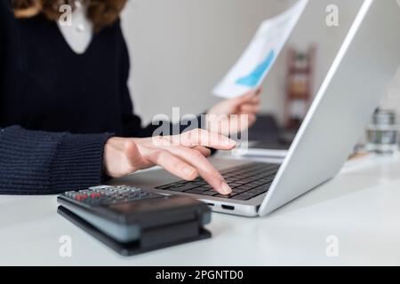 Businesswoman using laptop at desk Stock Photo