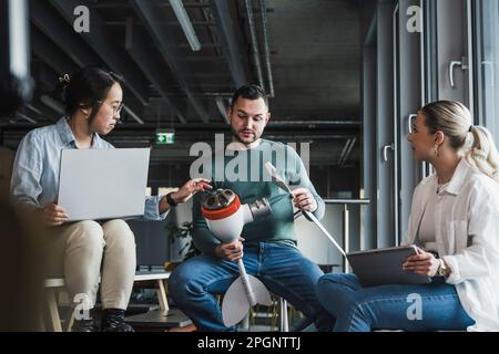 Businessman holding wind turbine rotor in meeting with colleagues at office Stock Photo