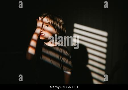 Boy covering one eye with hand Stock Photo - Alamy