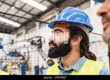 Thoughtful engineer with beard in factory Stock Photo