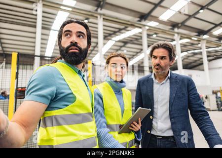 Thoughtful engineers wearing protective work wear in factory Stock Photo