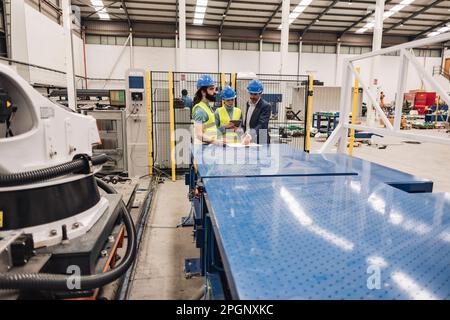 Engineers working together in robotics factory Stock Photo