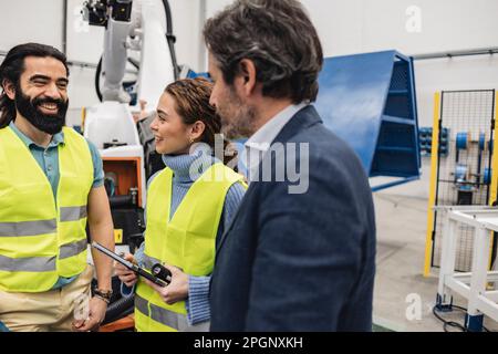 Smiling engineers having discussion in factory Stock Photo