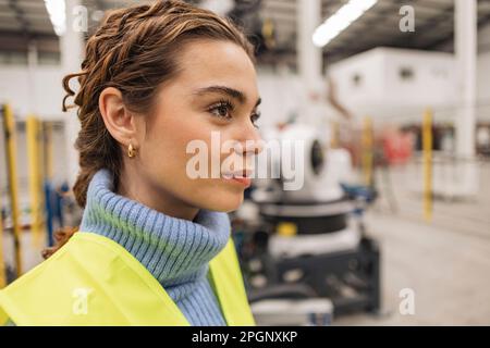 Thoughtful engineer wearing reflective clothing in factory Stock Photo