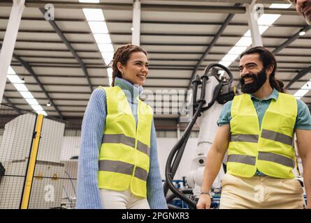 Happy engineers having fun in robotics factory Stock Photo