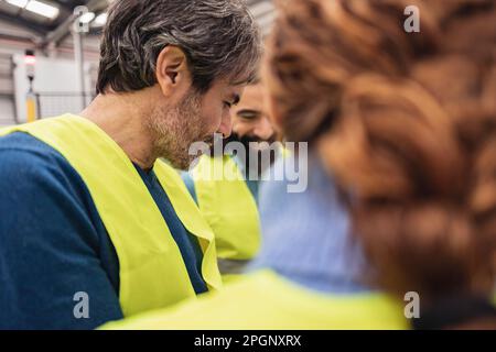 Engineers working with colleague in factory Stock Photo