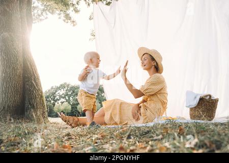 Happy mother giving high-five to son at park Stock Photo