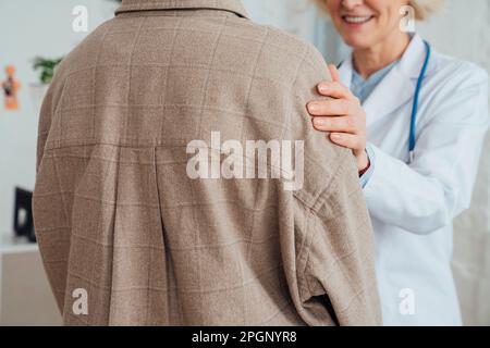Mature doctor consoling patient at clinic Stock Photo