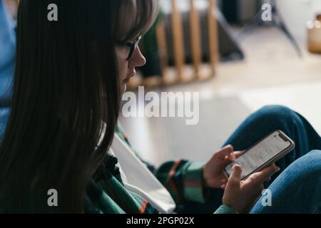 Young woman using smart phone at home Stock Photo