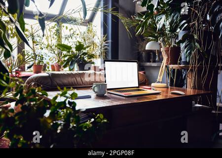 Laptop with blank screen on desk at loft office Stock Photo