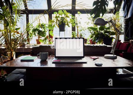 Laptop with blank screen on desk at loft office Stock Photo