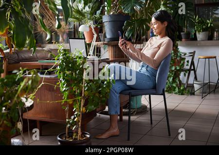 Smiling businesswoman surfing net through smart phone at loft office Stock Photo