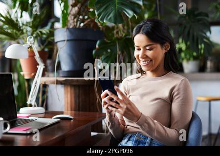 Happy freelancer text messaging through smart phone at loft office Stock Photo
