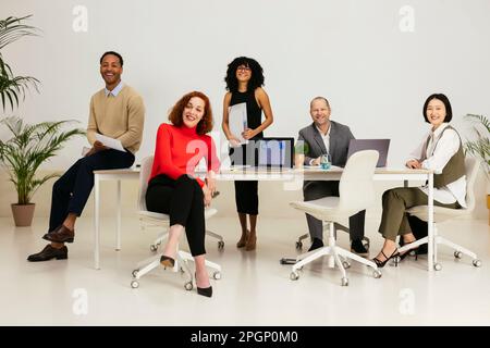 Multiracial business people sitting in meeting room at office Stock Photo
