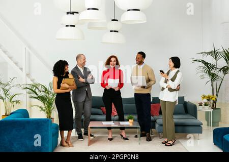Multiracial business people standing at office and give high five each ...